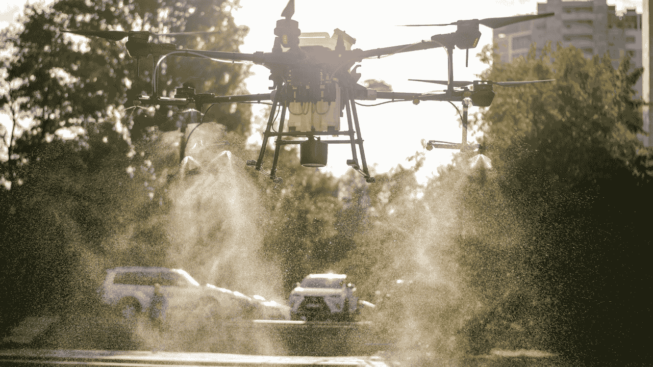 महिला बचतगट शेतात ड्रोनद्वारे औषध फवारणी करताना